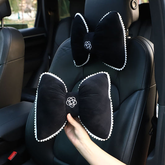 plush black headrest with camellia and butterfly knot design