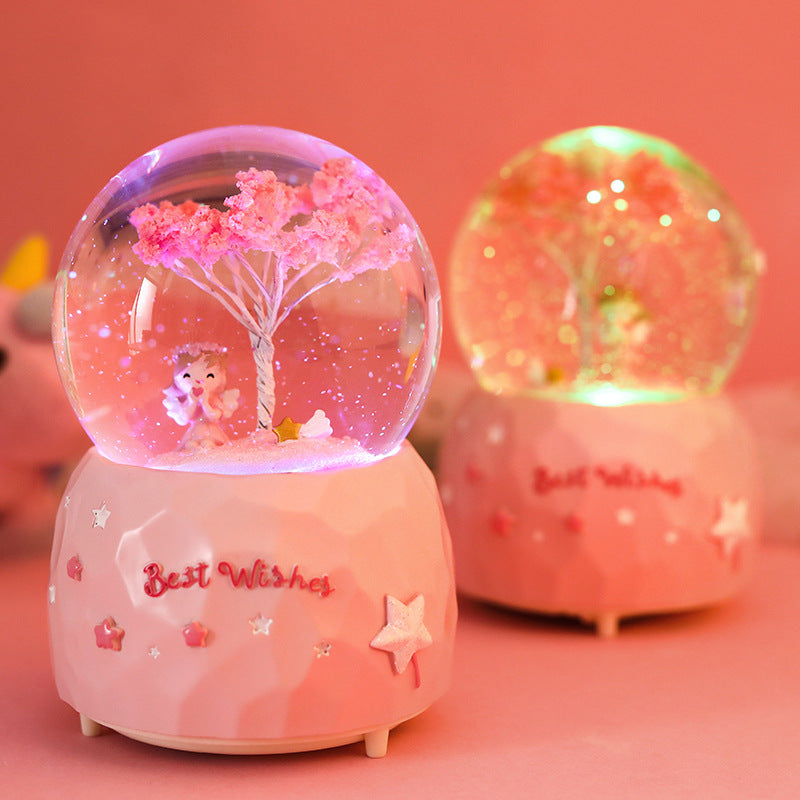 snow globe with illuminated cherry blossom angel