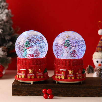 Close-up of rotating Christmas figures in snow globe